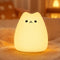 Veilleuse chat en silicone allumee jaune chaud dans une chambre cosy