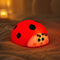 Veilleuse coccinelle en silicone en ambiance cosy sur textile doux