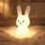 Veilleuse bébé lapin en silicone en ambiance cosy sur textile doux