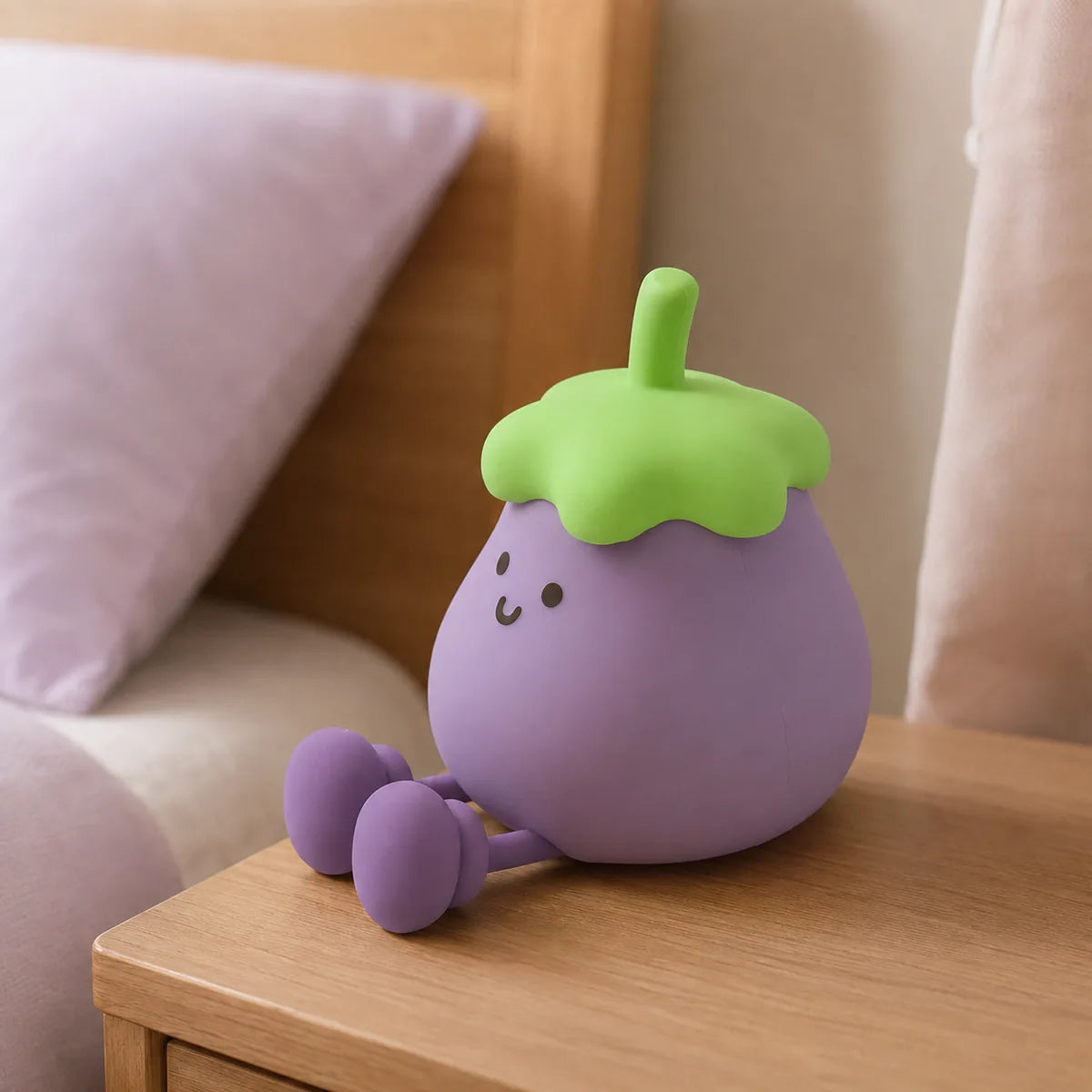 Veilleuse aubergine en silicone éteinte, posée sur une table de chevet