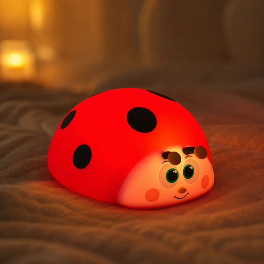 Veilleuse coccinelle en silicone en ambiance cosy sur textile doux