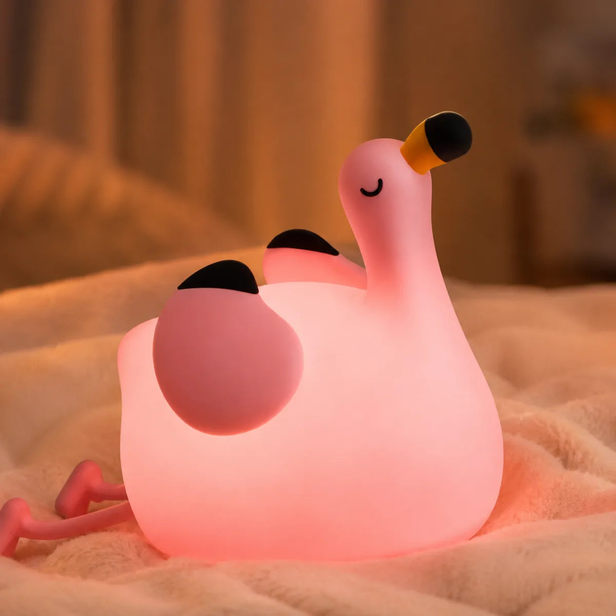 Veilleuse flamant rose en silicone en ambiance cosy sur textile doux