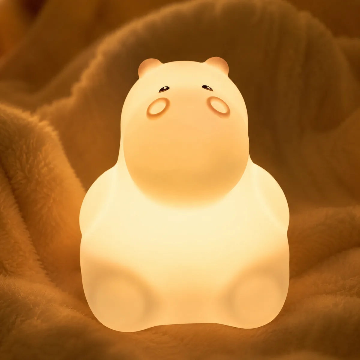 Veilleuse hippopotame en silicone en ambiance cosy sur textile doux