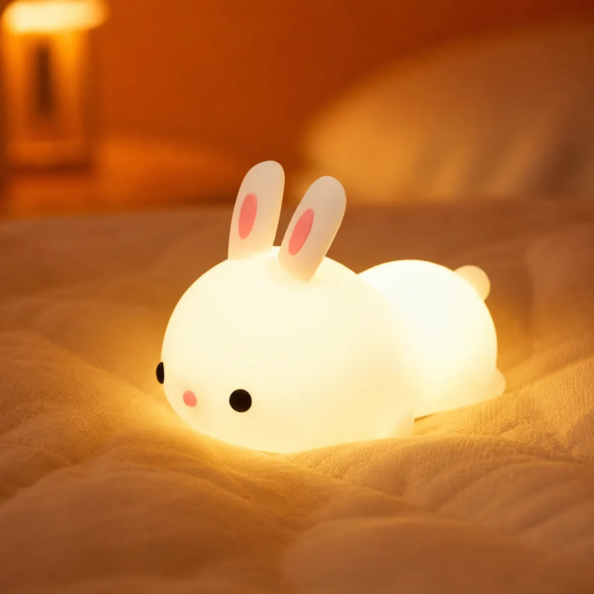 Veilleuse bébé lapin RGB en ambiance cosy sur textile doux