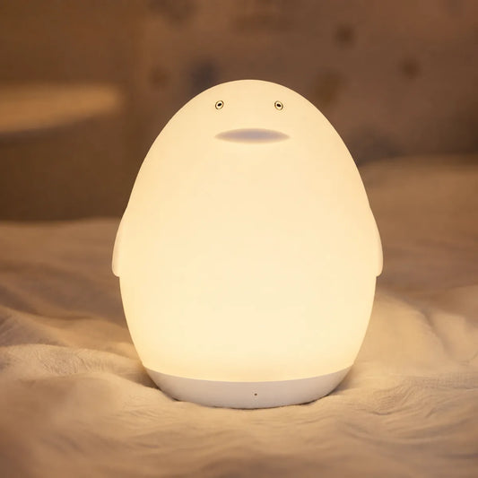 Veilleuse pingouin nomade allumée dans une chambre de bébé