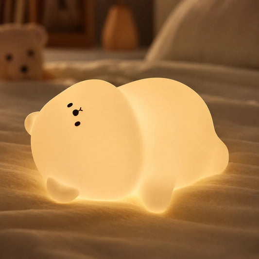 Veilleuse ours silicone allumee dans une chambre d'enfant cosy